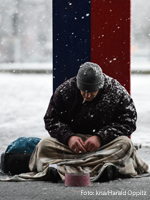 Ein Obdachloser sitzt im Winter auf der Straße. Foto: kna/Harald Oppitz