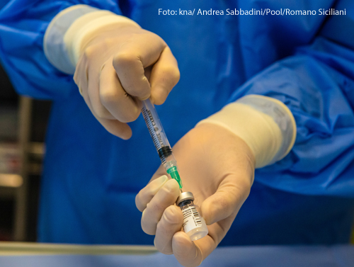  Ein Arzt zieht den Impfstoff gegen das Coronavirus in eine Spritze hoch. 