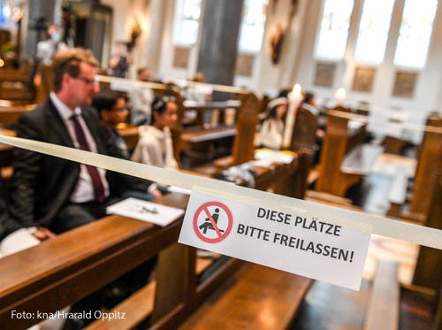 Eine Kirchenbank ist mit Absperrband verschlossen