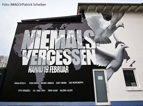 Ein Graffiti an einer Hauswand erinnert an den Anschlag von Hanau vor einem Jahr. "Niemals vergessen" steht darauf", daneben sind die Namen der Opfer und zwei Friedenstauben abgebildet.