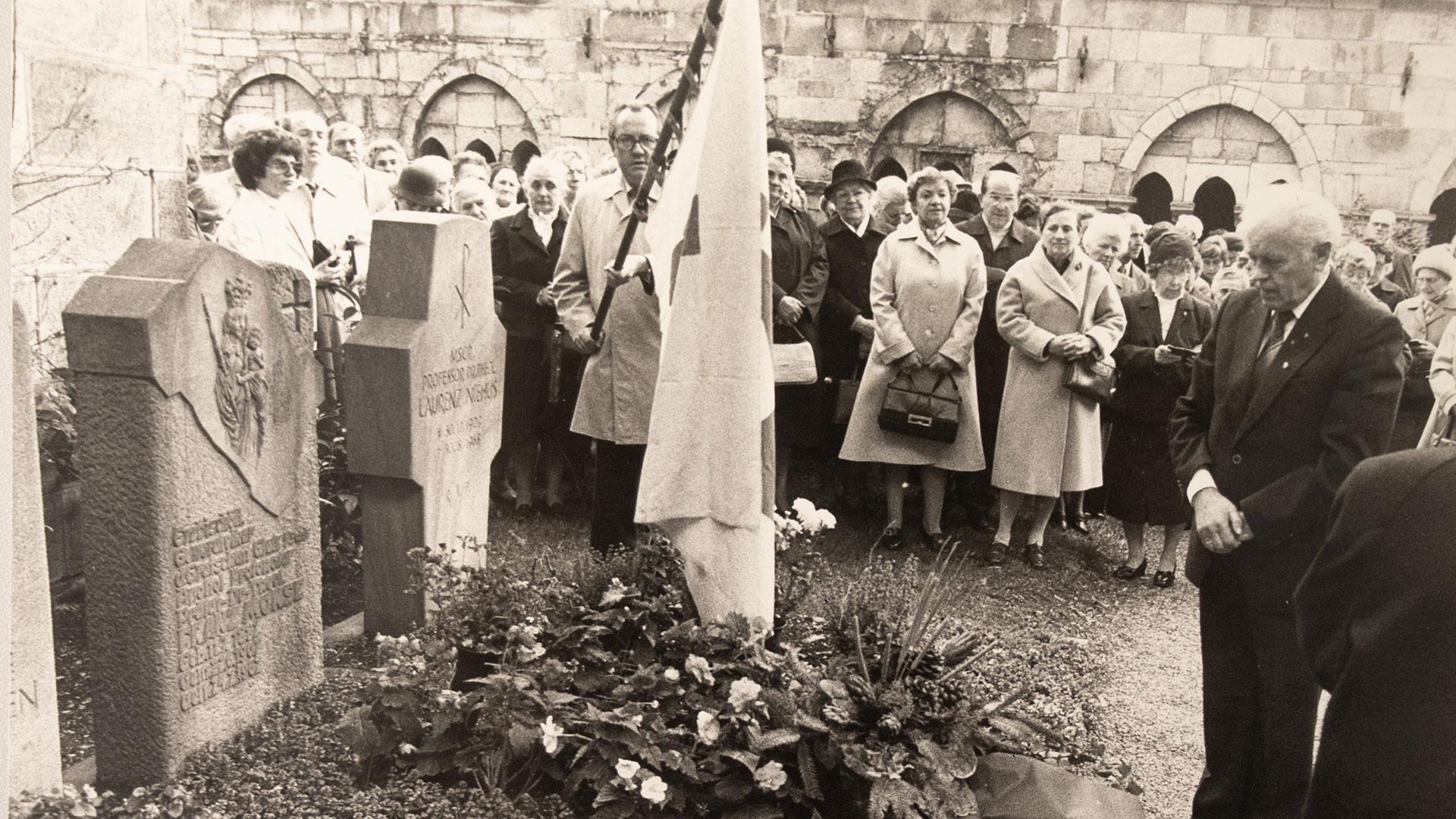 Menschen stehen um ein Grab im Kreuzgang des Osnabrücker Domes