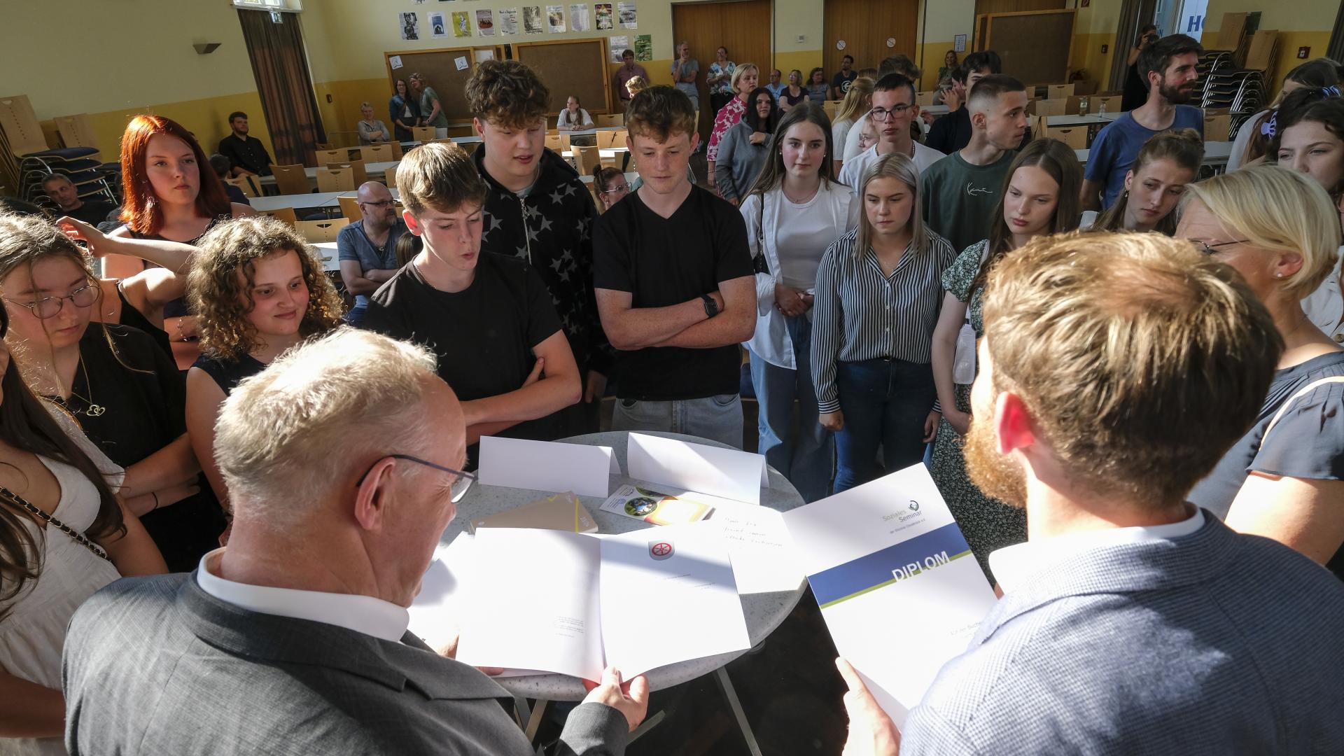 Eine Gruppe junger Leute steht um einen Tisch herum