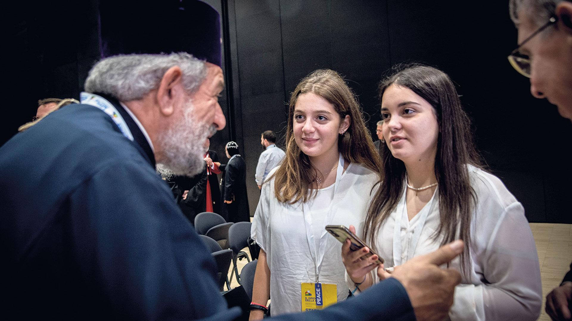 Ein Religonsführer im Gespräch mit zwei "einfachen" jungen Christinnen.