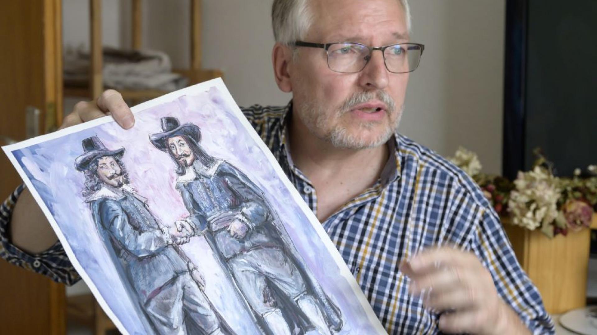 Peter Eickmeyer hält sein Bild vom Osnabrücker Handschlag hoch