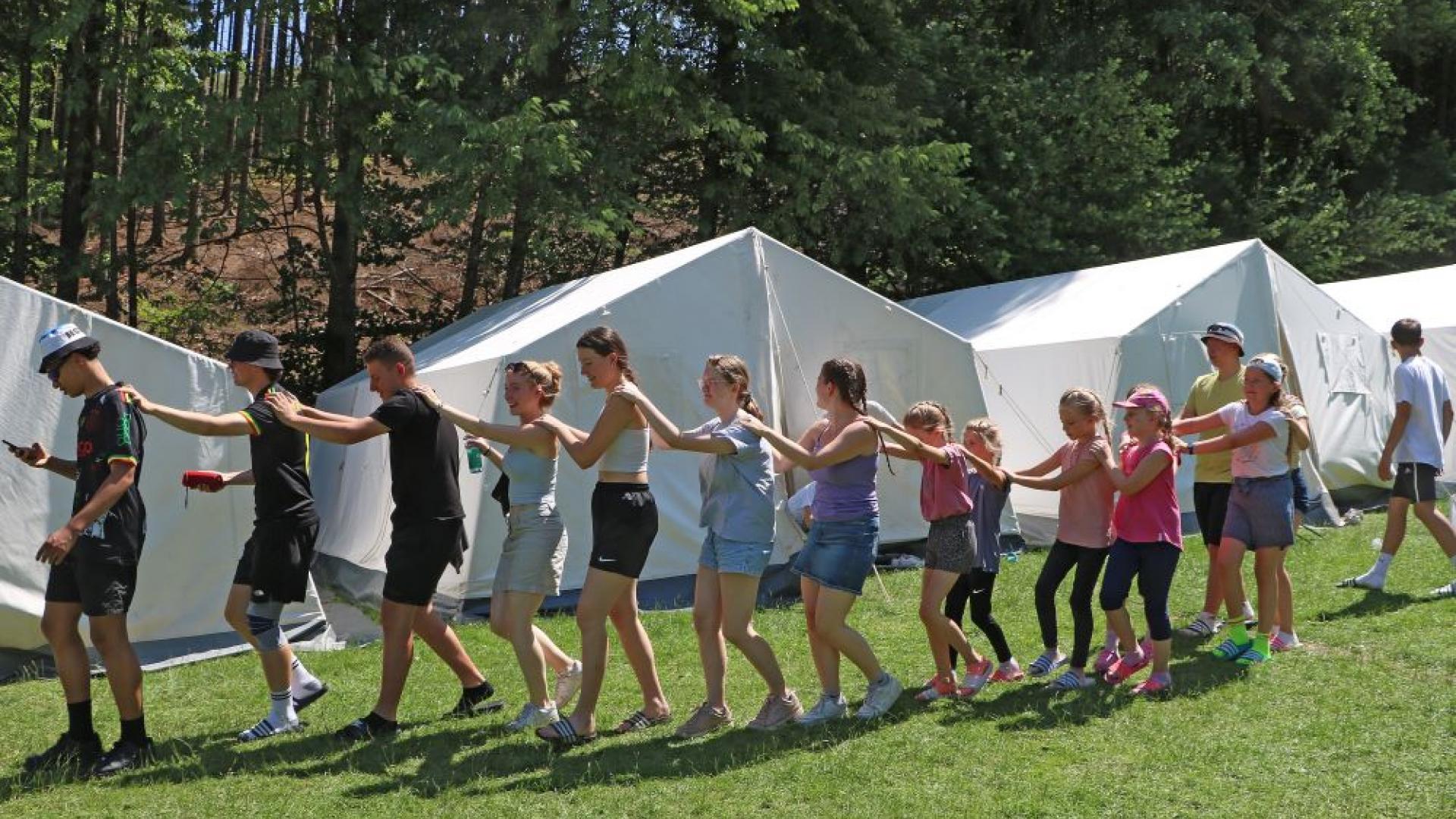 Jugendliche im Zeltlager vor Zelten
