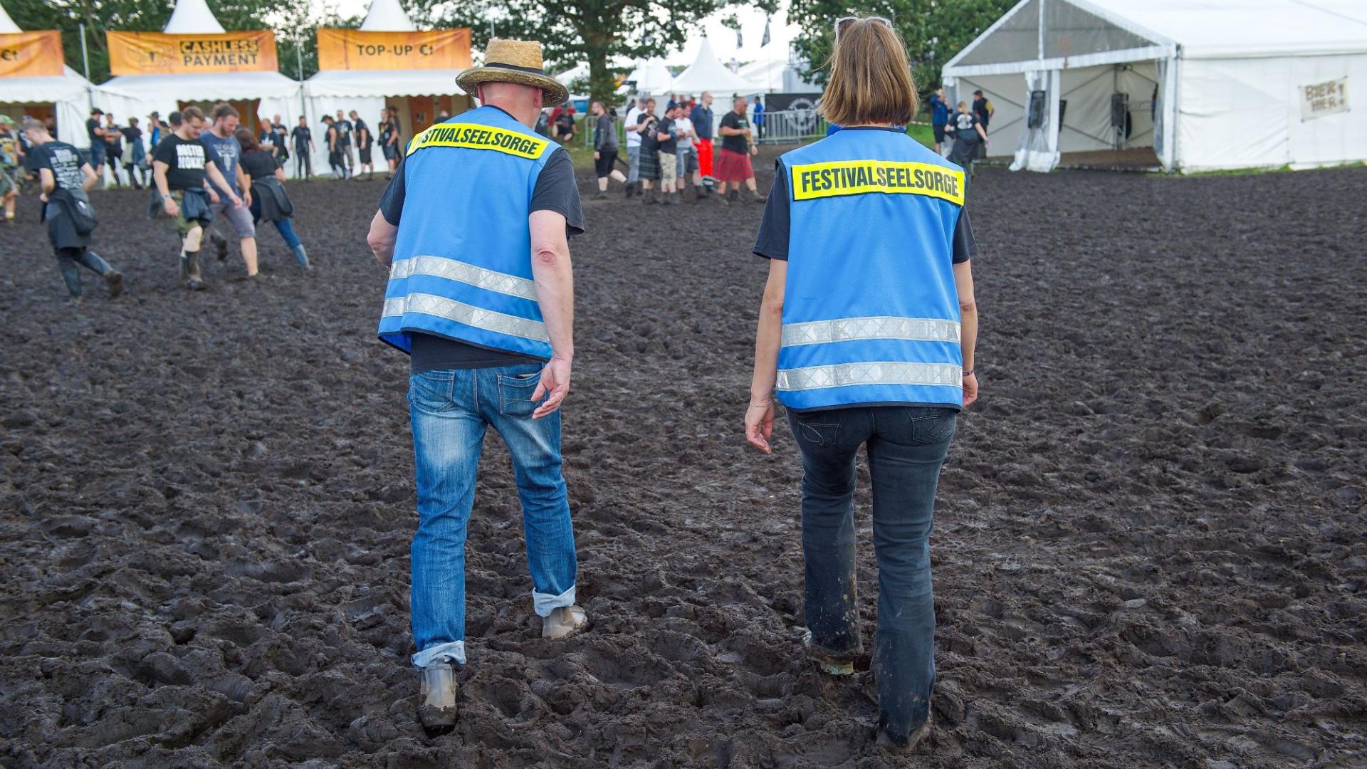 Zwei Seelsorger unterwegs durch den Matsch auf dem Festivalgelände des Wacken Open Air