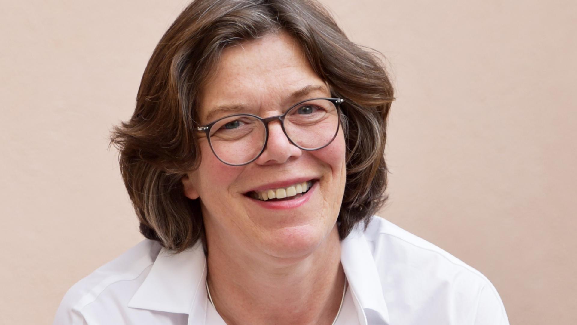 eine Frau mit weißer Bluse und Brille