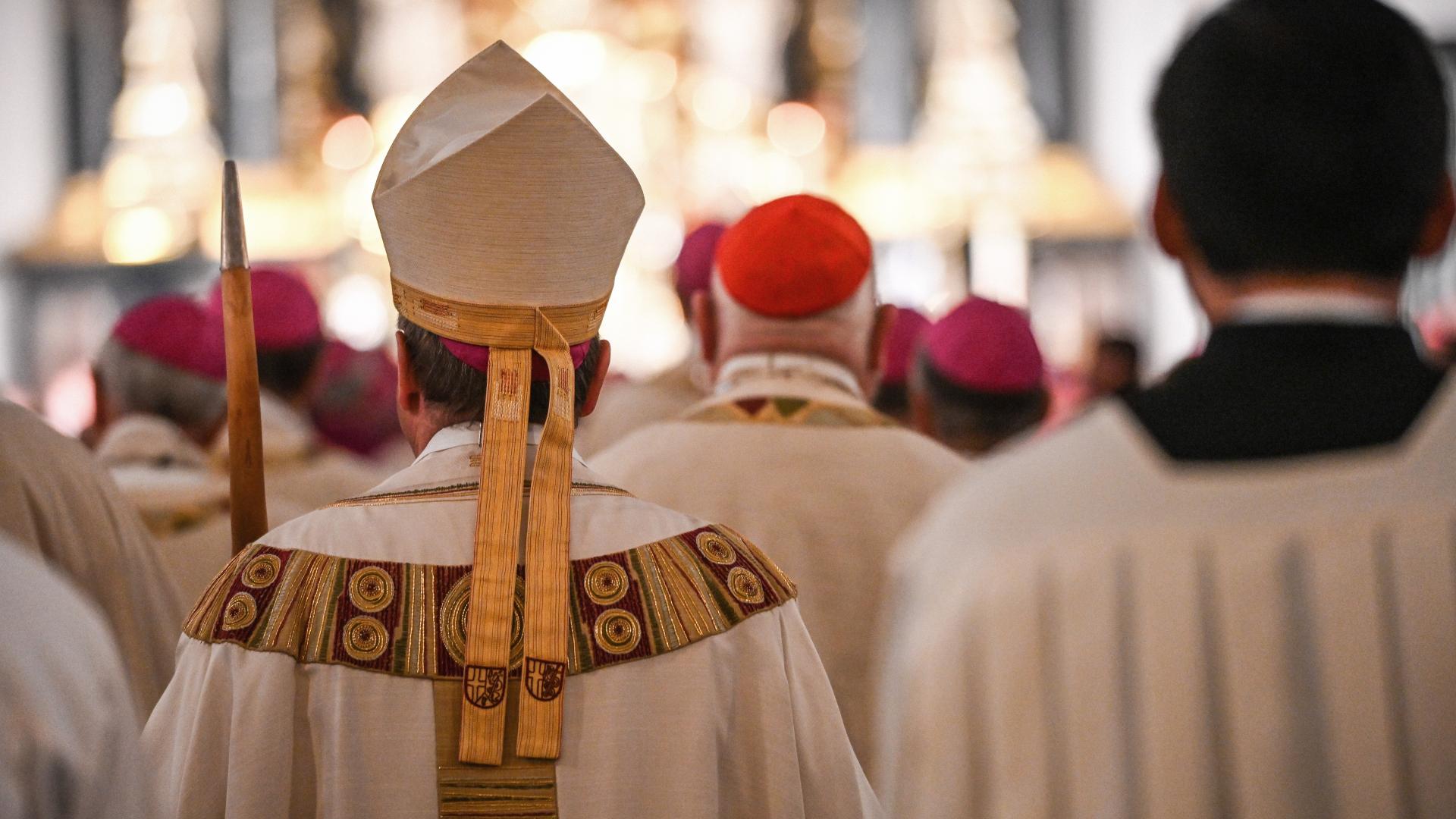 Blick von hinten auf Bischöfe, die in eine Kirche einziehen