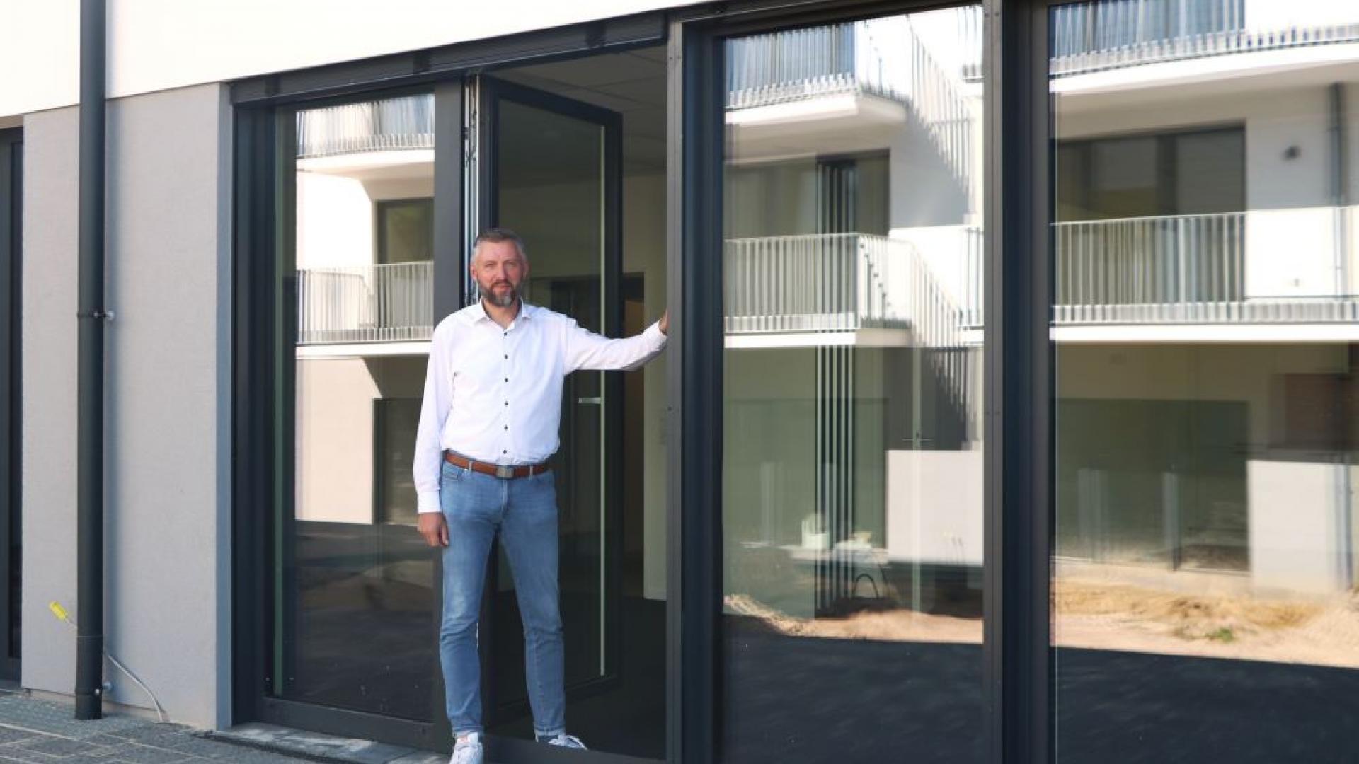 Caritas-Geschäftsführer vor dem neuen Gebäude