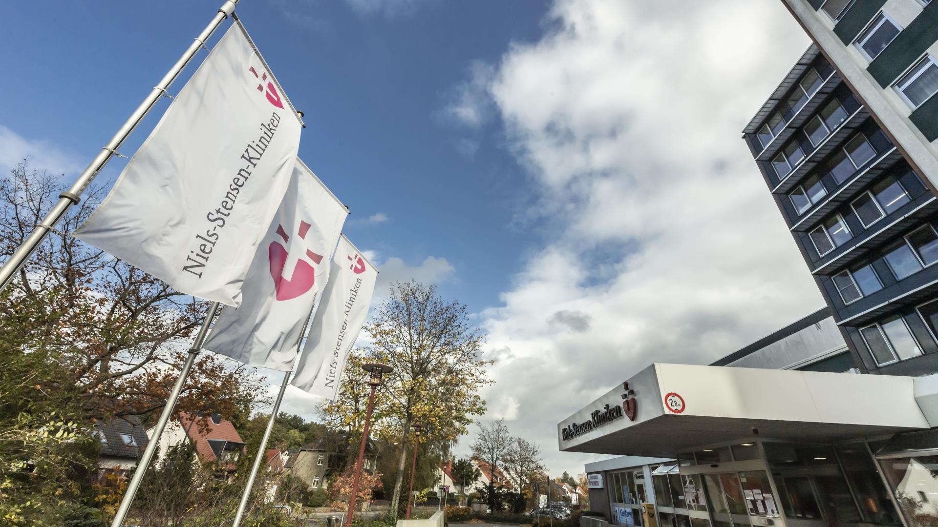 Fahnen wehen vor einem hohen Krankenhausgebäude