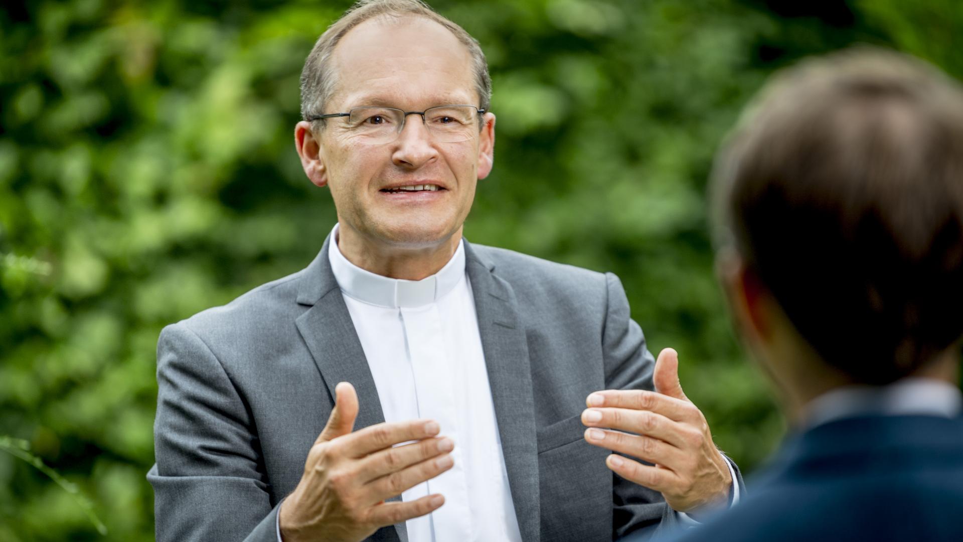 Ein Priester unterhält sich mit einem Mann