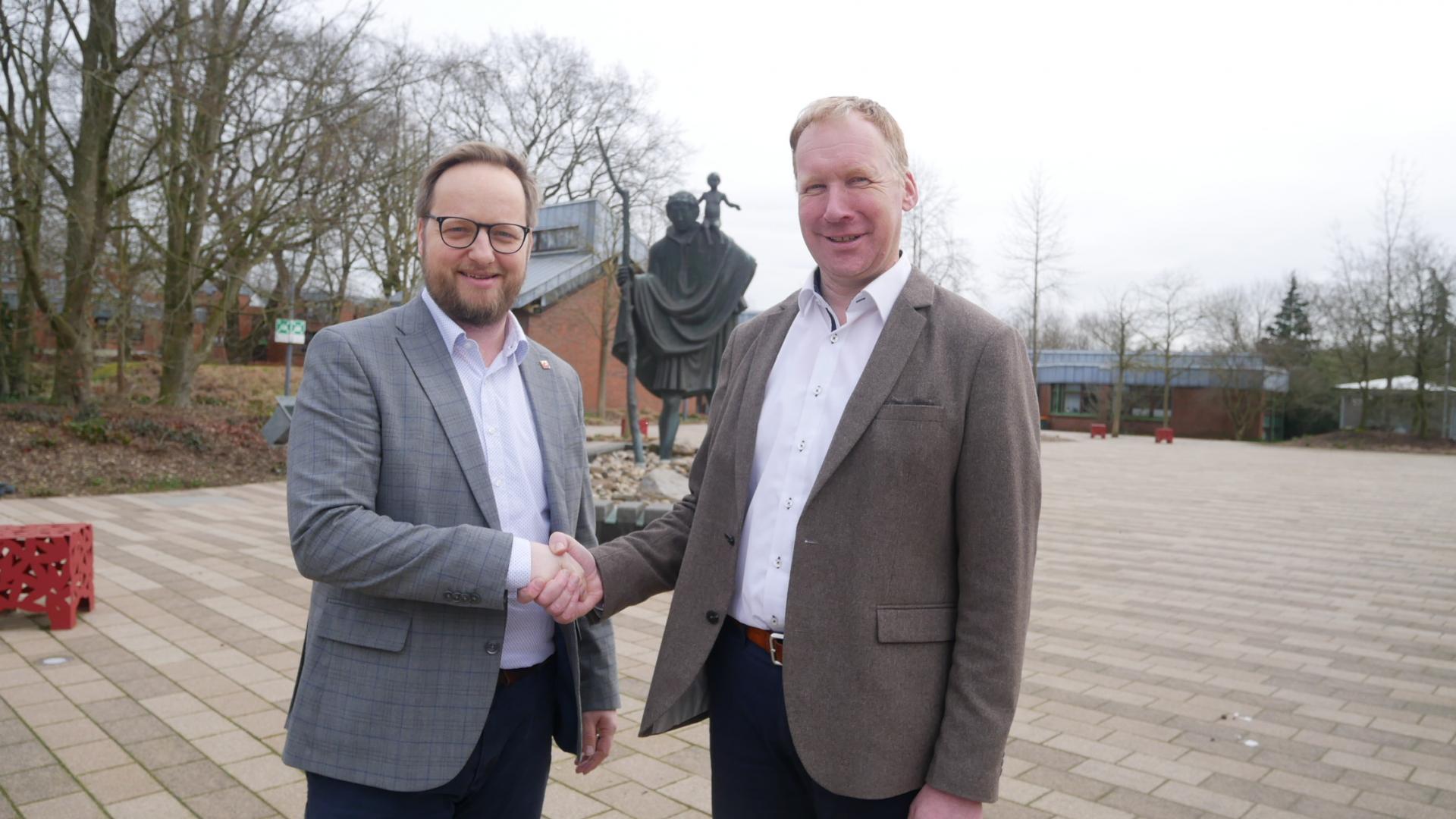 Zwei Männer reichen sich die Hand.