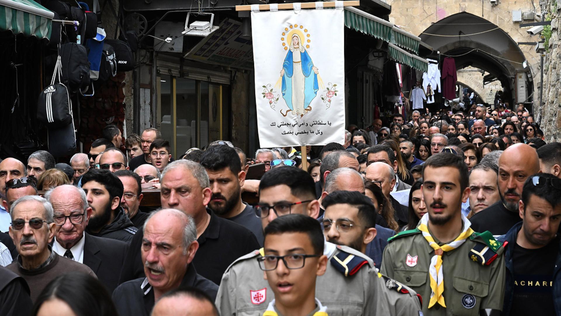 Christen gehen, begleitet von Pfadfindern durch die engen Gassen Jerusalems