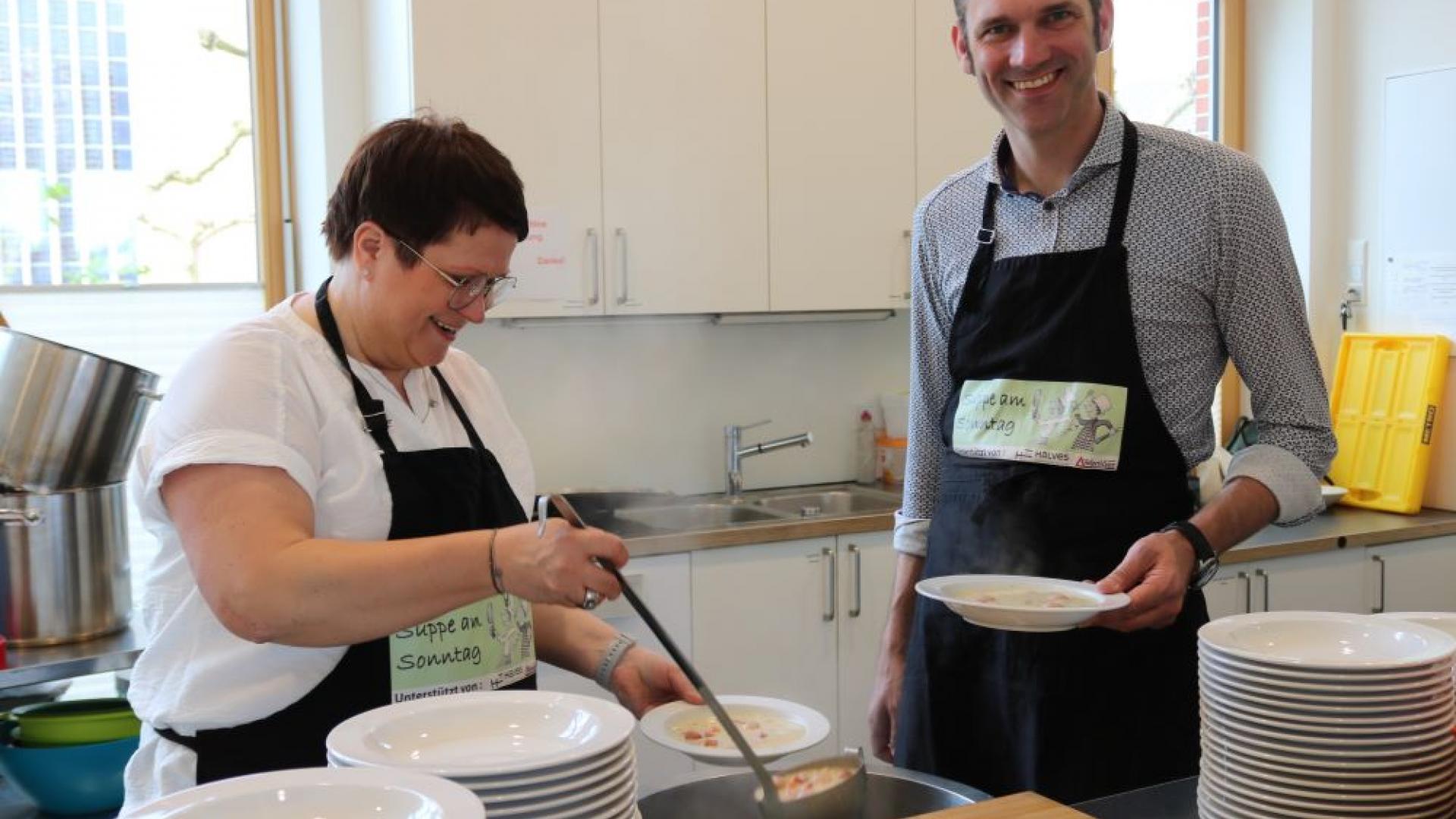 Frau und Mann kochen Suppe