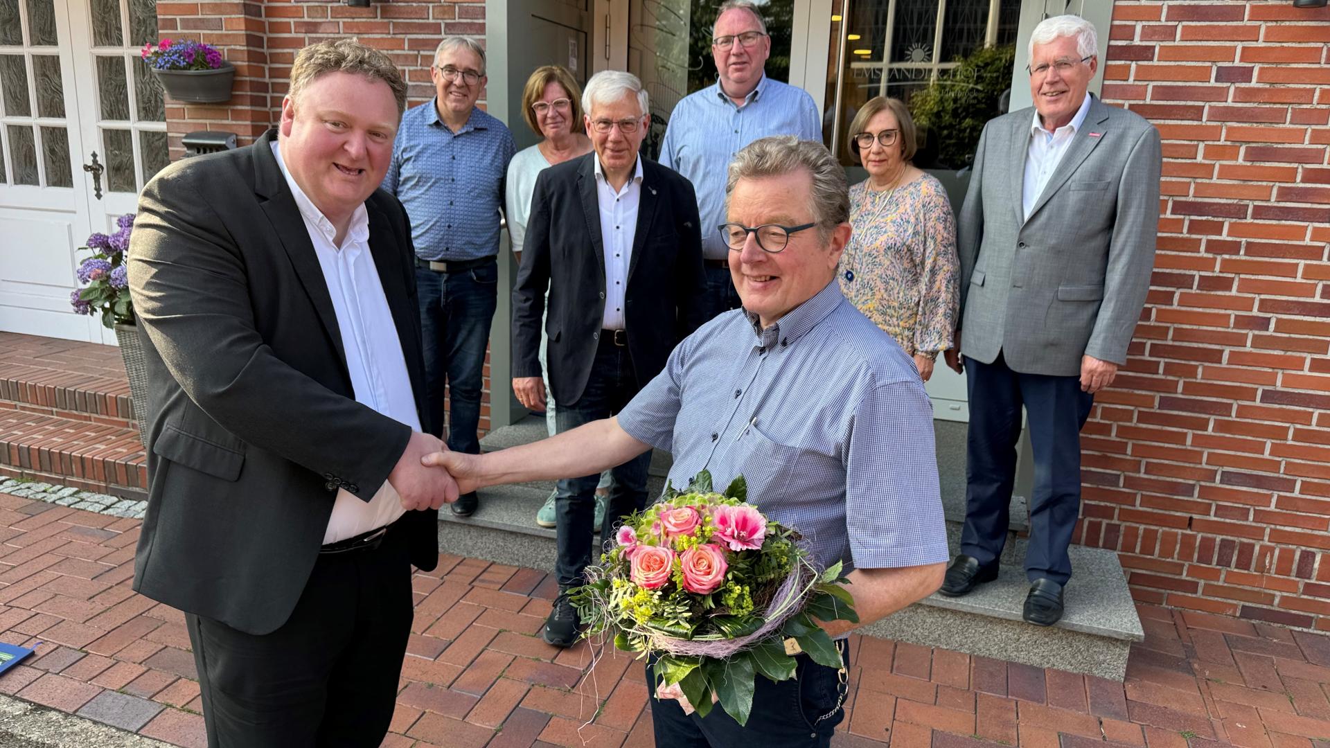 Eine Gruppe von Menschen vor einem Haus.