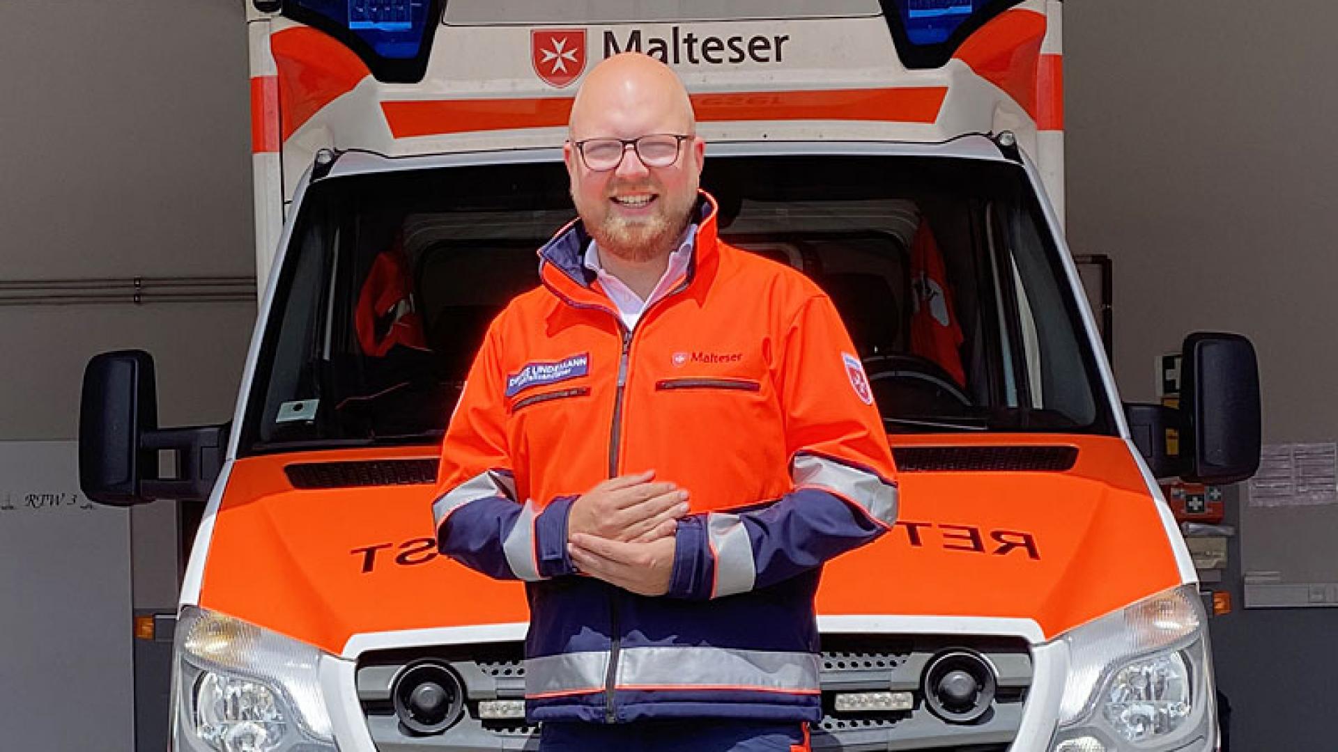 Portätfoto von einem Mann in Uniform vor einem Krankenwagen